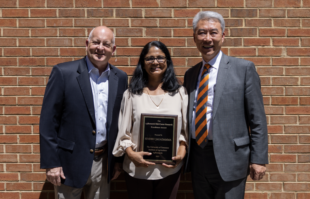 Sindhu Jagadamma holding the Mid-Career Faculty Research Excellence Award with UTIA Senior Vice Chancellor and Senior Vice President Keith Carver and UT AgResearch Dean Hongwei Xin